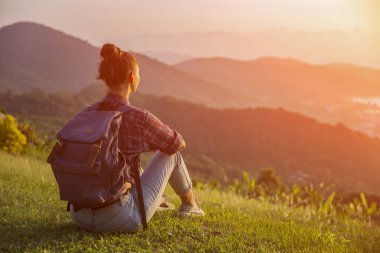 Hippi kız en yüksek dağında gün batımı zevk sırt çantası ile. Arka plan Vadisi manzara görünümü mockup üzerinde turist gezgin. Tonda. Instagram filtre