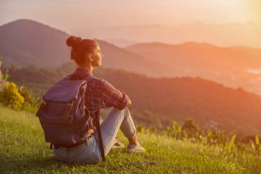 Hippi kız en yüksek dağında gün batımı zevk sırt çantası ile. Arka plan Vadisi manzara görünümü mockup üzerinde turist gezgin. Tonda. Instagram filtre