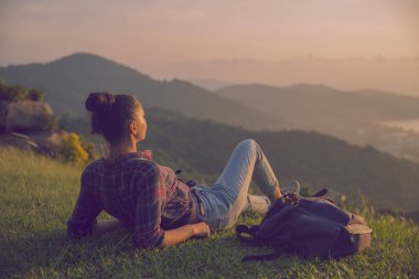 Hippi kız en yüksek dağında gün batımı zevk sırt çantası ile. Arka plan Vadisi manzara görünümü mockup üzerinde turist gezgin. Tonda. Instagram filtre