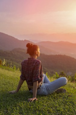 Hippi kız en yüksek dağında gün batımı zevk sırt çantası ile. Arka plan Vadisi manzara görünümü mockup üzerinde turist gezgin. Tonda. Instagram filtre