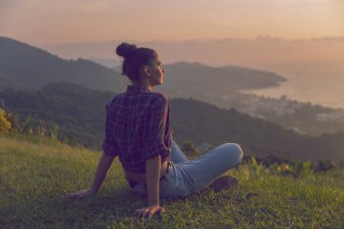 Hippi kız en yüksek dağında gün batımı zevk sırt çantası ile. Arka plan Vadisi manzara görünümü mockup üzerinde turist gezgin. Tonda. Instagram filtre