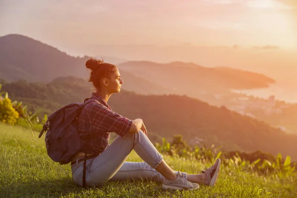Hippi kız en yüksek dağında gün batımı zevk sırt çantası ile. Arka plan Vadisi manzara görünümü mockup üzerinde turist gezgin. Tonda. Instagram filtre