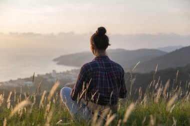 Hipster genç kız en yüksek dağında gün batımı zevk. Arka plan Vadisi manzara görünümü mockup üzerinde turist Gezgin.