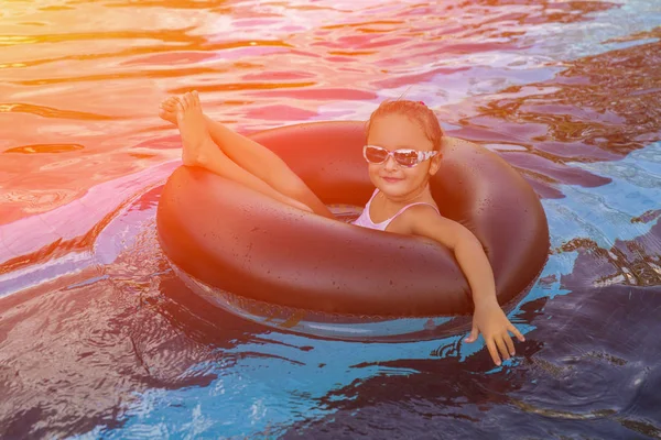 Sıcak yaz gününde şişme halka açık yüzme havuzunda oynamaktan mutlu küçük kız. Yüzmeyi öğrenmek. Çocuk su oyuncakları. Çocuk tropikal beldesinde oyun. Aile beach tatil. Tonda