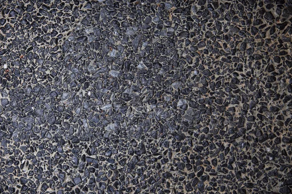 Abstraktes Hintergrundpflaster bestehend aus kleinen Kieselsteinen, die in Zement eingebettet sind — Stockfoto