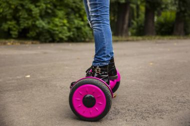 Vurgulu kurulu çocuk. Çocuklar parkta sürme. Çocuklar için denge kurulu. Elektrik kendini şehir sokak motorla Dengeleme. Kız Hoverboard binmek için öğrenme. Okul çocuk için modern araçlar.