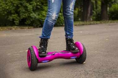 Vurgulu kurulu çocuk. Çocuklar parkta sürme. Çocuklar için denge kurulu. Elektrik kendini şehir sokak motorla Dengeleme. Kız Hoverboard binmek için öğrenme. Okul çocuk için modern araçlar.