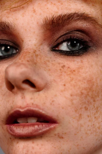 Gros plan macro portrait du visage féminin. Demi-visage de femme humaine avec maquillage beauté jour. Fille avec la peau parfaite et les taches de rousseur . — Photo