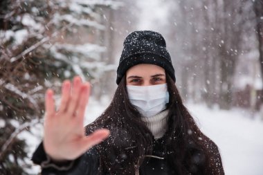 Telaşlı kadın görünümü, koronavirüs enfeksiyonuna karşı tıbbi maske takıyor. Ölümcül Coronavirus China 2019 2020-ncov. Protesto imzala, elini uzat.