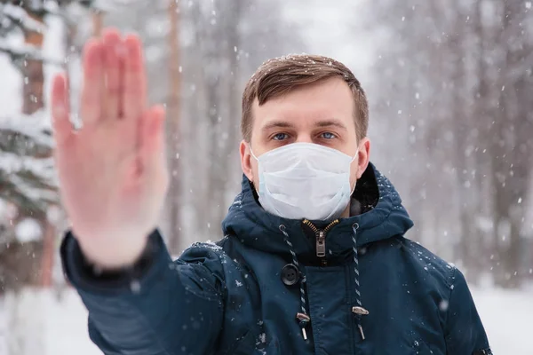 Khawatir penampilan laki-laki memakai topeng medis melindungi terhadap infeksi coronavirus takut. Penobatan mematikan China 2019 2020 2019-nCoV. Tanda tangan protes, ulurkan tangan ke depan — Stok Foto