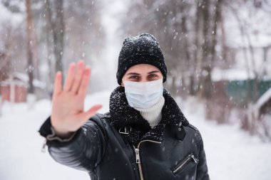 Telaşlı kadın görünümü, koronavirüs enfeksiyonuna karşı tıbbi maske takıyor. Ölümcül Coronavirus China 2019 2020-ncov. Protesto imzala, elini uzat.