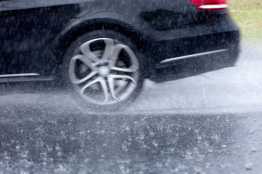 Hareket eden araba yağmuru Tekerleklerden fışkıran su birikintisi