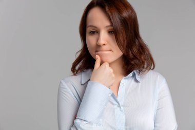 Kafkasyalı güzel bir kadının portresi şüpheli bir ifade takınıyor, kurnazca kararsızlıkla kafasını çeviriyor, çenesini tutuyor, en iyi çözümü bulmaya çalışıyor. Vücut dili kavramı.