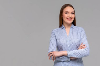 Her şey yolunda olduğu için mutluyum. Dost canlısı beyaz bir kızın portresi. Diş telleri neşeyle gülümserken monokromatik arka plan karşısında duruyor. Dinleme emri ya da iş arkadaşıyla konuşuyor.