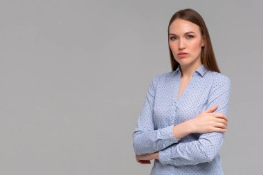 Çekici, kendine güvenen, yaratıcı, güzel görünümlü, patronluk taslayan, kollarını kavuşturan, kendine güvenen, gülümseyen, kendine güvenen, hedeflerine ulaşan, şanslı, tek renkli arka plan sahibi bir kadın.