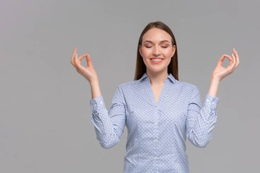 Diş teli takan kız huzur sabrını hissediyor. Çekici, kaygısız, rahat, mutlu, genç kadın, gülümseyen, gülümseyen, mutlu eller, yandan meditasyon yapan nirvana nilüfer çiçeği pozu, nefes alma pratiği yapan yoga.