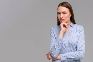 Hmm, bir düşüneyim. Odaklanmış genç kız öğrenci, çene tutarken somurtuyor, alt köşeye bakıyor, düşünüyor, karar veriyor ya da plan yapıyor.