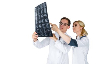 Beyaz arka planda duran doktorlar klinikteki Covid-19 hastasının zatürresi için röntgen çekiyorlar.