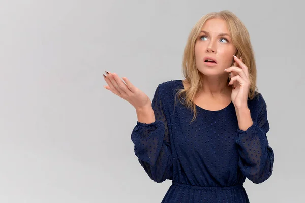 Milenyum kadınının akıllı telefondan tartışırken ki görüntüsü. Sinirli genç bir kadın cep telefonuyla konuşur, kötü haberleri telefonla duyar. Gri renkte cep telefonu olan bir kızın portresi