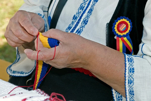 Стара жінка плете один пояс вручну — стокове фото