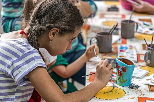 Ragazza che dipinge una ciotola di ceramica — Foto Stock