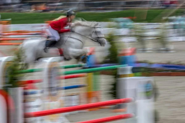 Imagem abstrata com um cavaleiro e um cavalo em movimento no salto da mostra — Fotografia de Stock