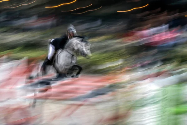 Imagem abstrata com um cavaleiro e um cavalo em movimento no salto da mostra — Fotografia de Stock