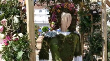 Timisoara, Romanya - 27 Nisan 2018: Çiçek dekorasyon çiçeklerden yapılmış bir popüler Kostüm giymiş bir kadın ahşap heykel ile. Belediye tarafından düzenlenen çiçek Festivali.