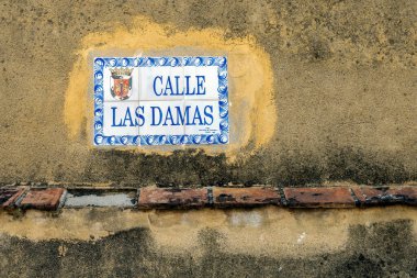 Calle Las Damas, Santo Domingo, Dominik Cumhuriyeti yazılı. Şehirdeki ve Amerika 'daki ilk cadde, 1502' de inşa edilmiş. Bu isim geldi çünkü kadınlar o caddede dolaşıyordu..