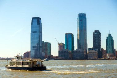 NEW YORK, ABD - 9 Mart 2020: Jersey City 'deki gökdelenleri Manhattan' dan Rockefeller Park 'a, Hudson Nehri boyunca öğleden sonra ışığı altında.