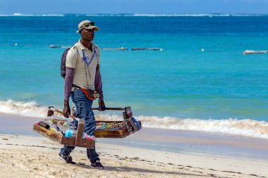 PUNTA CANA, DOMINICAN REUBLIC - 11 Mart 2020: Sahilde satılık ürünlerini sunan Dominikli bir adamın portresi.