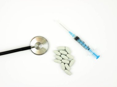 plastik şırınga, hap ve beyaz arka plan üzerinde stetoskop