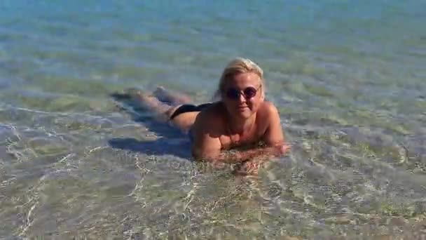 Красивая девушка в море на песке — стоковое видео