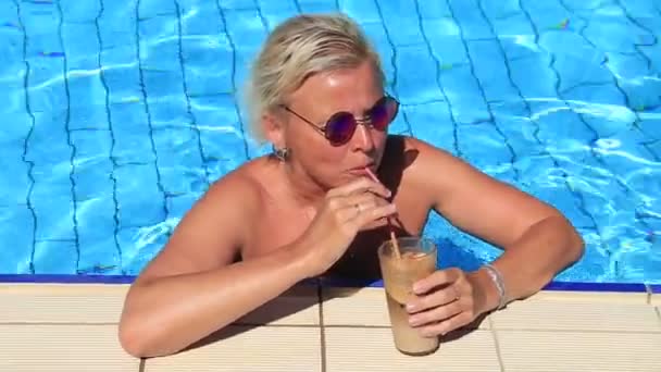 Het meisje in het zwembad van een cocktail te drinken — Stockvideo