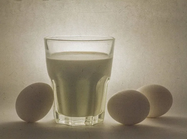 Latte in un vaso di vetro e uova — Foto Stock