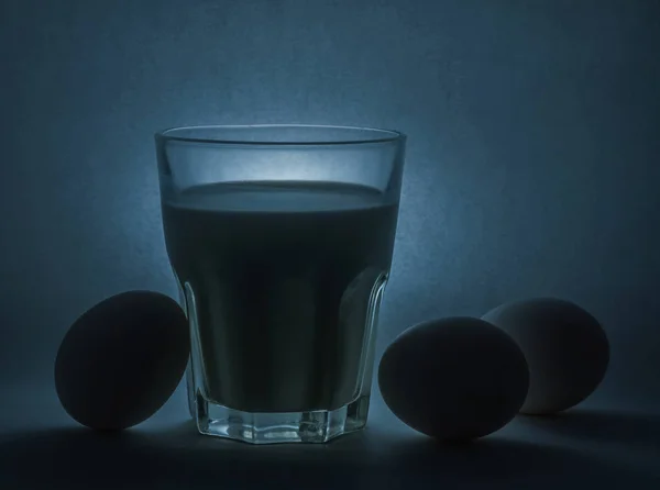 Latte in un vaso di vetro e uova — Foto Stock