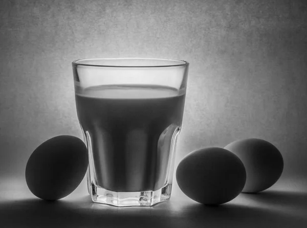 Latte in un vaso di vetro e uova — Foto Stock
