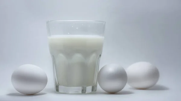 Молоко в стеклянной банке и яйцах — стоковое фото