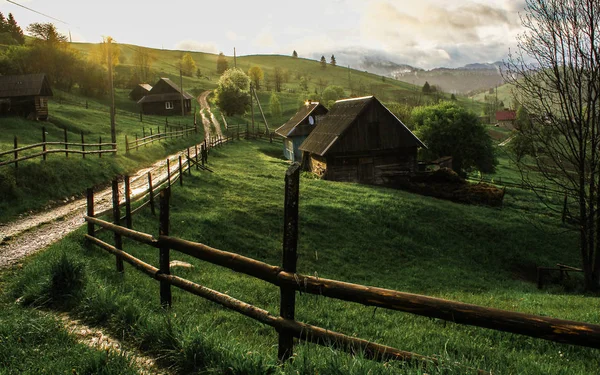 Raios de sol da manhã na casa de montanhas de nevoeiro — Fotografia de Stock