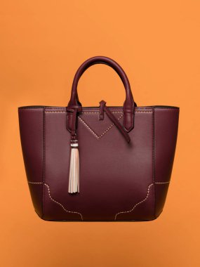 Güzel lüks deri kadın kırmızı çanta turuncu bir arka plan üzerinde