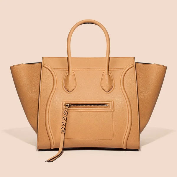 Bej renkli arka plan üzerinde deri bej lüks çanta