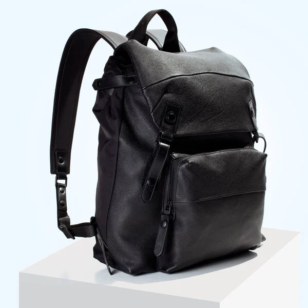 Deri lüks siyah sırt çantası bir beyaz küp ve mavi arka plan