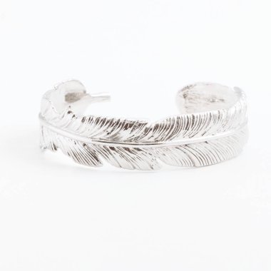 Gri bir arka plan üzerinde bir tüy şeklinde lüks ince güzel gümüş bileklik