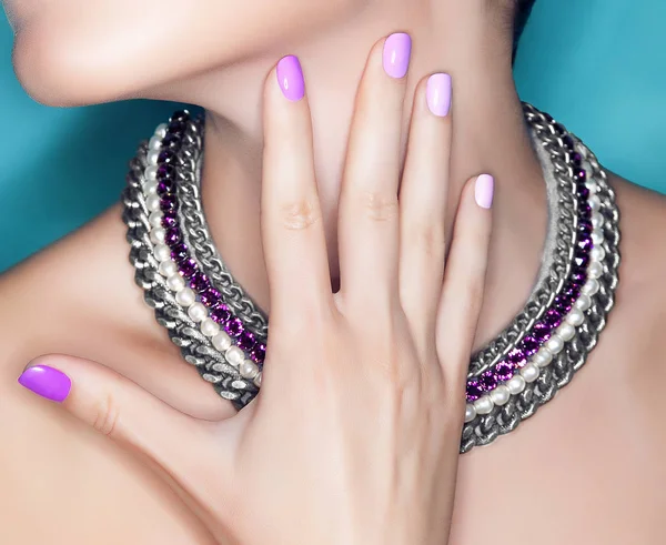 Mooie vrouwelijke hand met manicure op de nagels op de hals met een ketting — Stockfoto