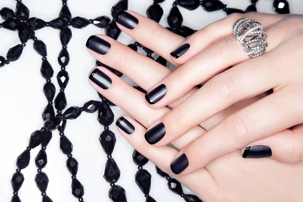 Close-up van handen met manicure op nagels, zwart, wit — Stockfoto