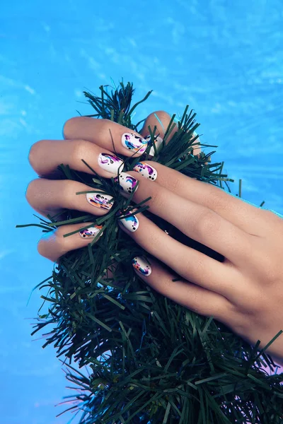 Close-up van handen met manicure op nagels winter, kerstboom — Stockfoto