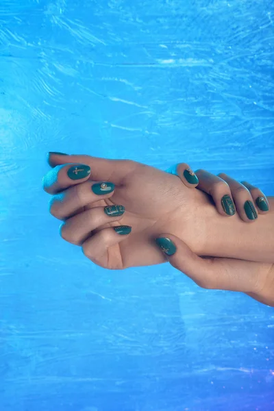 Primer plano de las manos con hermosa manicura en las uñas invierno, verde, oro — Foto de Stock