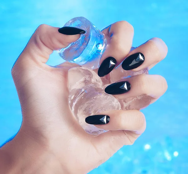 Primer plano de las manos con manicura negra y plateada en las uñas invierno, hielo —  Fotos de Stock