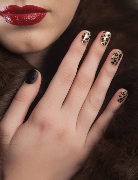 Zbliżenie: piękny manicure na paznokcie i usta na kobiece strony, futro, leopard — Zdjęcie stockowe