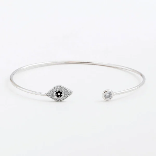 Luxurious slim beautiful silver bracelet with stones and eye on a gray background — Stock Photo, Image